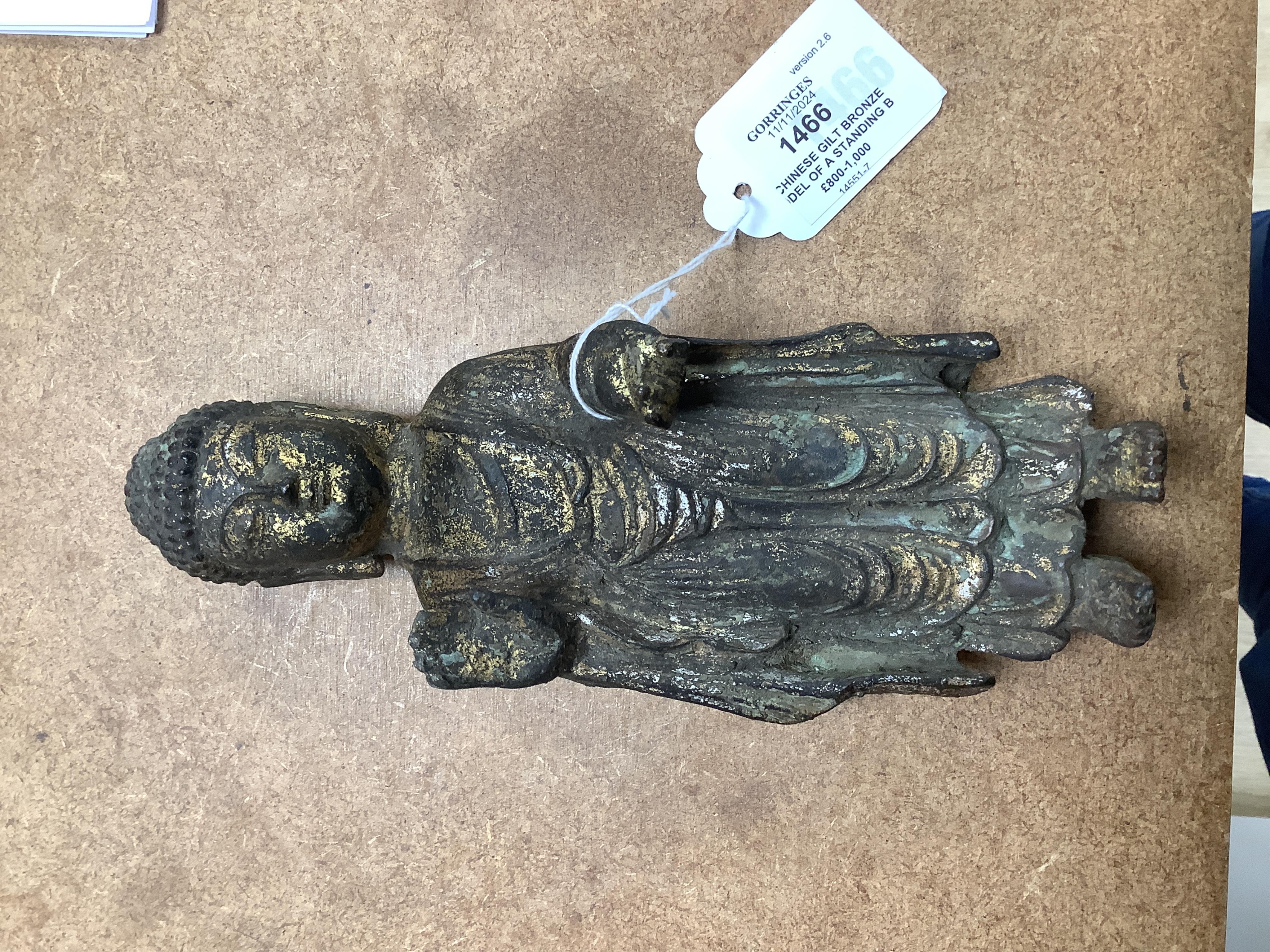 A Chinese gilt bronze model of a standing Buddha, 21.5cm. Condition - poor to fair